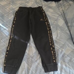 Adidas Kids Black Joggers with camoflauge pattern side stripes.